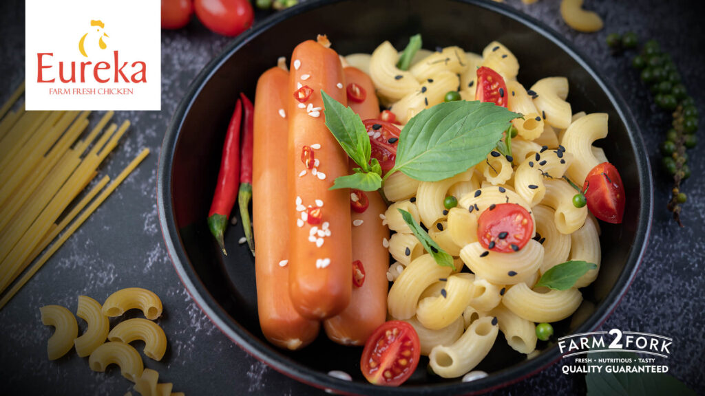 delicious macaroni and vienna garnished with pepper and tomatoes in a skillet